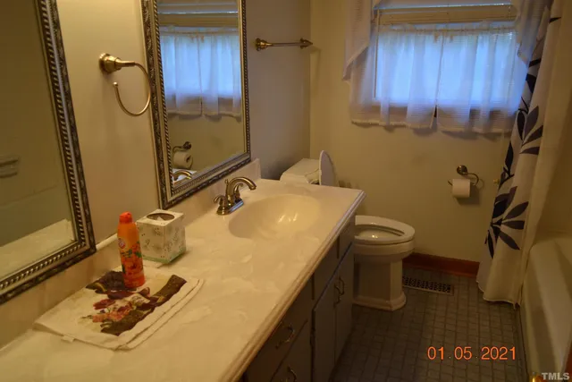 a bathroom with a granite countertop sink a toilet and a mirror