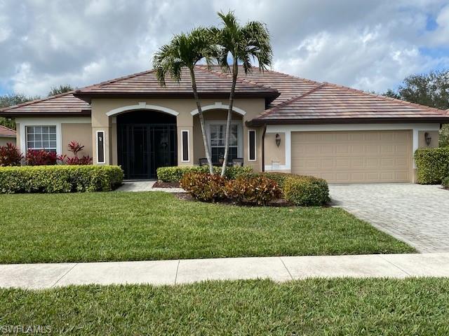 8886 Lely Island Circle Naples, FL 34113 - Photo 1 of 14 a front view of a house with a garden