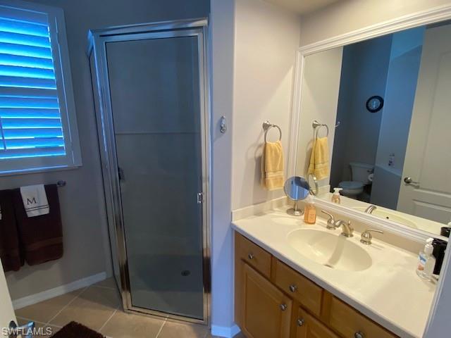 8886 Lely Island Circle Naples, FL 34113 - Photo 12 of 14 a bathroom with a shower sink vanity granite and mirror