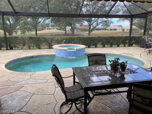 8886 Lely Island Circle Naples, FL 34113 - Photo 14 of 14 a view of a patio with table and chairs next to a yard