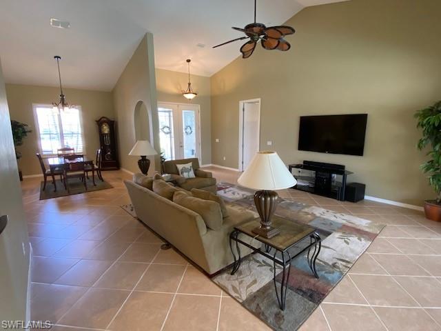 8886 Lely Island Circle Naples, FL 34113 - Photo 2 of 14 a living room with furniture a flat screen tv and a chandelier