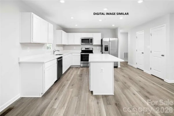a large kitchen with a large counter top appliances and cabinets