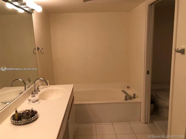 a bathroom with a tub sink and mirror