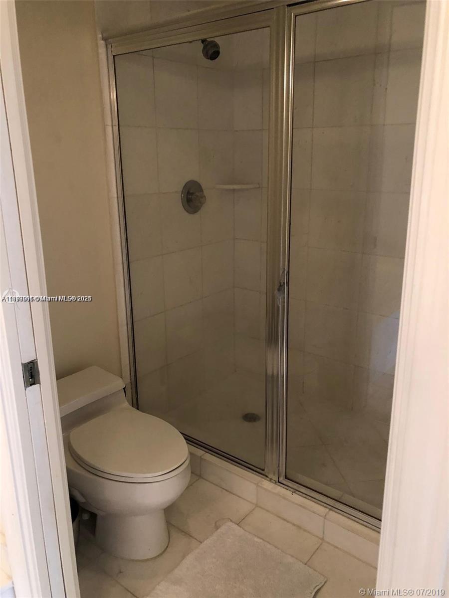 3530 Mystic Pointe Drive, Unit 1008 Aventura, FL 33180 - Photo 14 of 32 a bathroom with a toilet and a shower