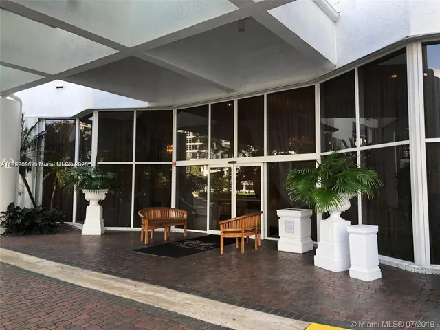 a living room with furniture potted plant and a large window