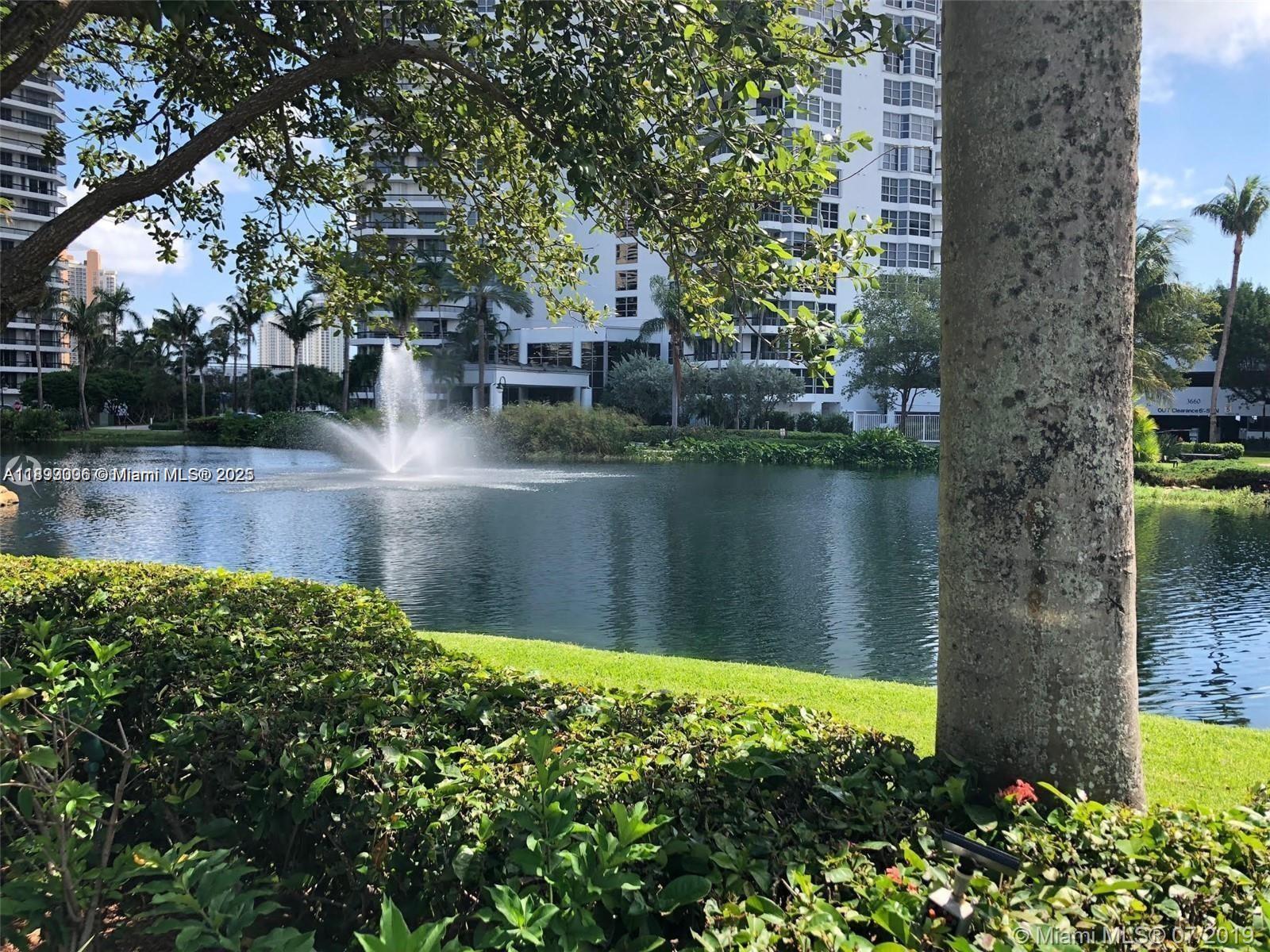 3530 Mystic Pointe Drive, Unit 1008 Aventura, FL 33180 - Photo 31 of 32 a backyard of a house with lots of green space and lake view