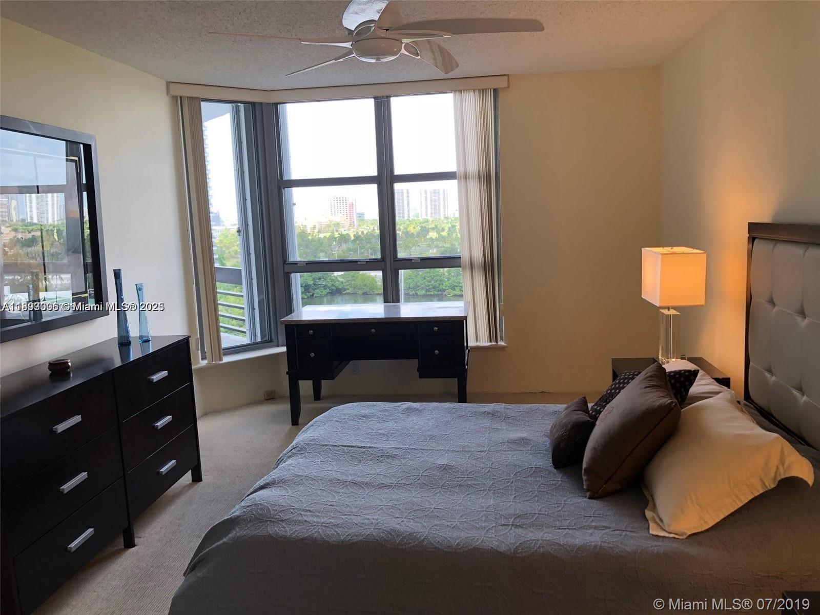 3530 Mystic Pointe Drive, Unit 1008 Aventura, FL 33180 - Photo 9 of 32 a bedroom with a bed and a window