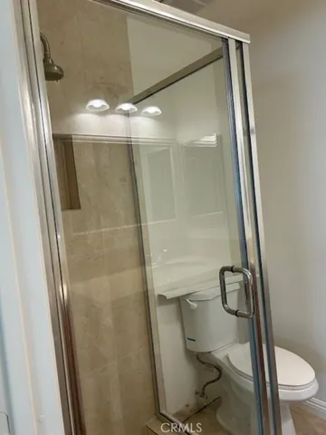 a bathroom with a granite countertop toilet and a shower