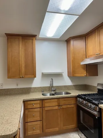 a kitchen with granite countertop a sink stainless steel appliances and cabinets