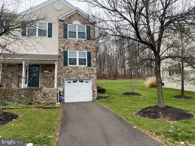 a front view of a house with a garden and yard