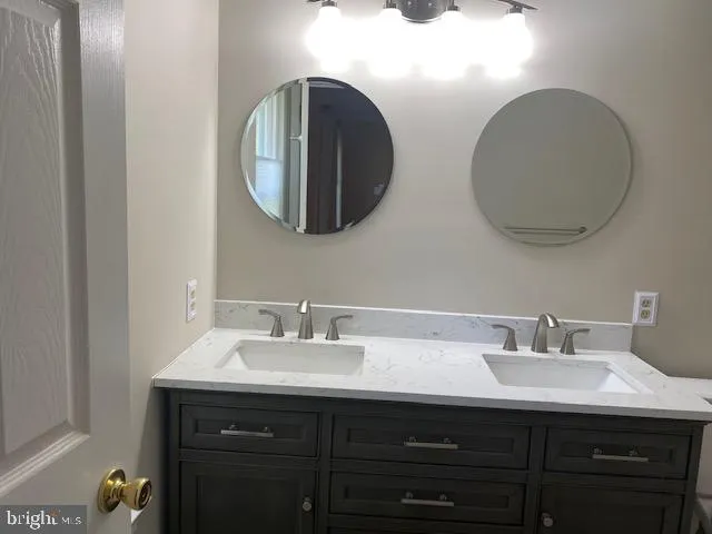 a bathroom with a double vanity sink and a mirror