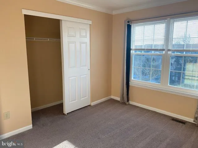 an empty room with windows and closet