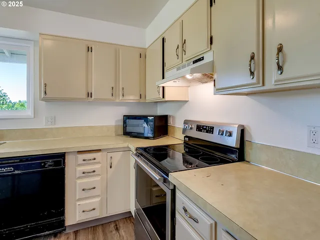 a kitchen with stainless steel appliances a stove a microwave and cabinets