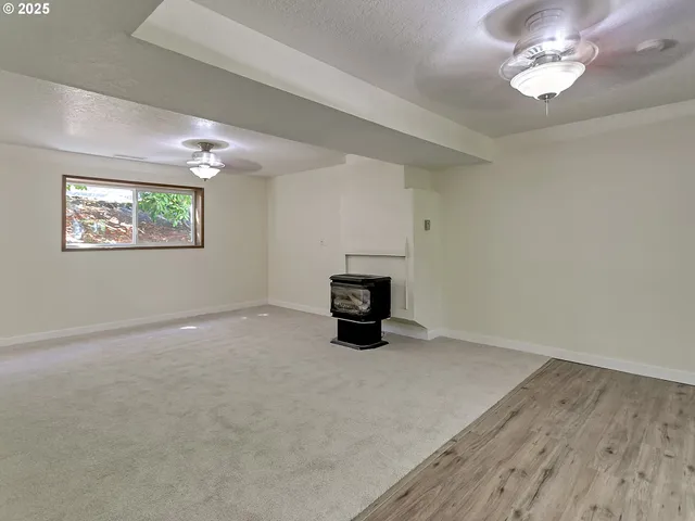 en empty room with windows and ceiling fan
