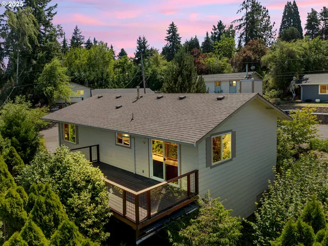 a aerial view of a house with balcony and trees al around