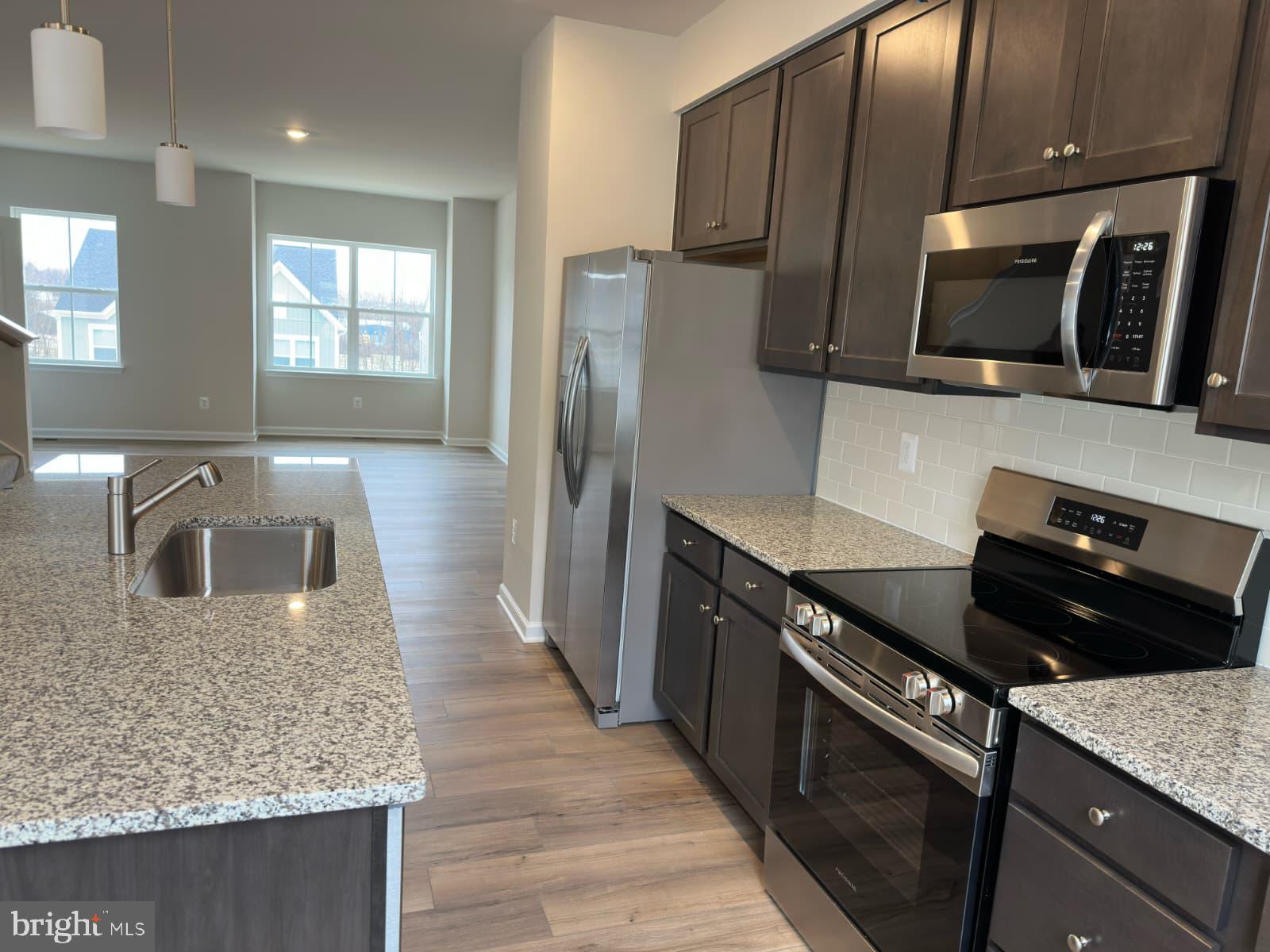 1256 Red Clover Lane, Unit 149 Ranson, WV 25438 - Photo 3 of 17 a kitchen with stainless steel appliances granite countertop a sink stove and microwave