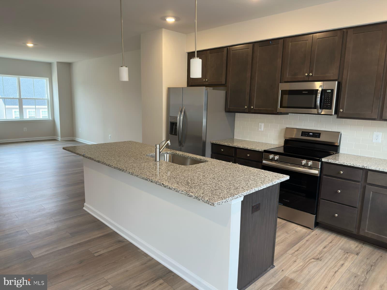 1256 Red Clover Lane, Unit 149 Ranson, WV 25438 - Photo 5 of 17 a kitchen with stainless steel appliances granite countertop a sink dishwasher a microwave oven and a refrigerator with wooden cabinets