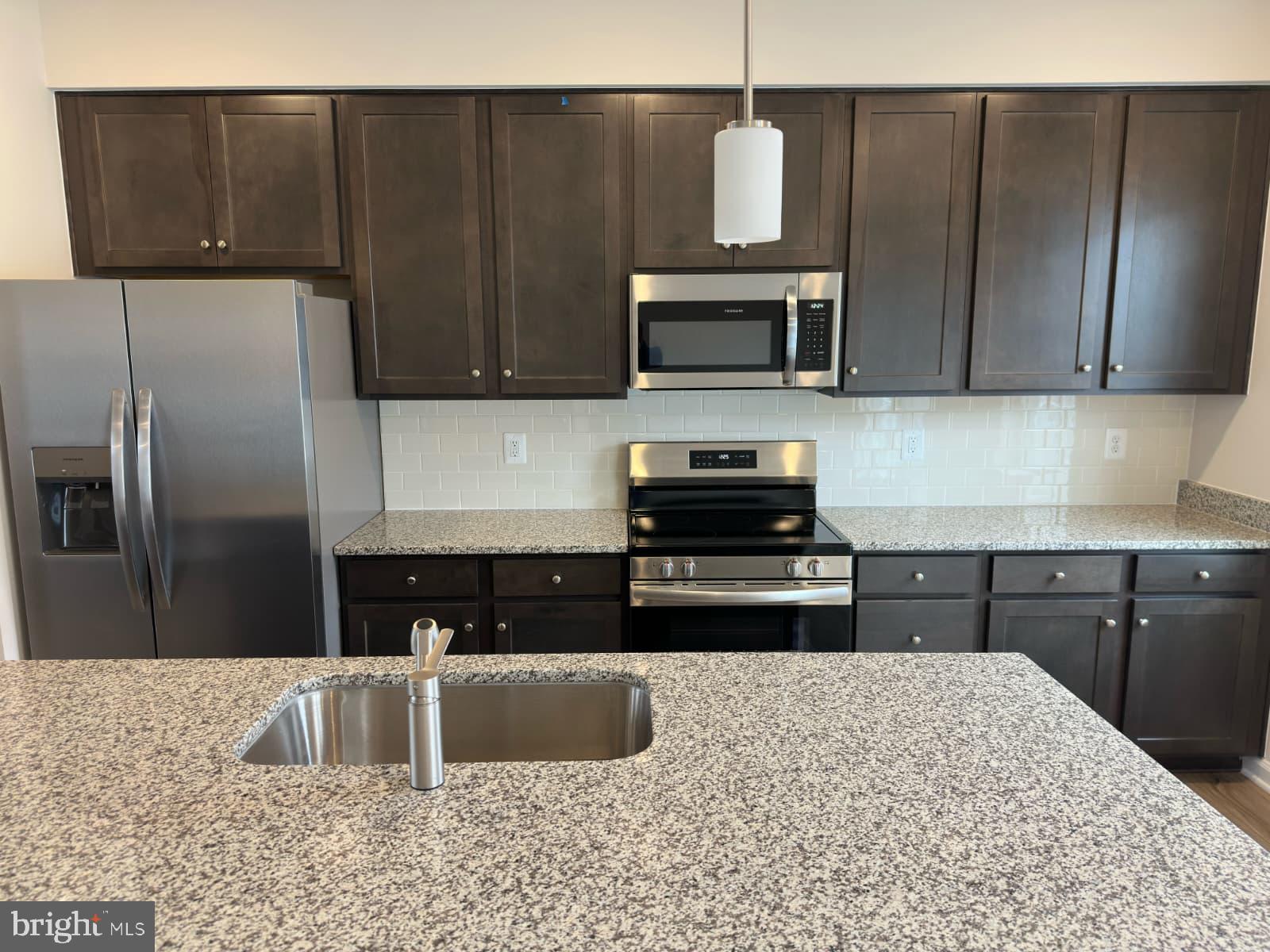 1256 Red Clover Lane, Unit 149 Ranson, WV 25438 - Photo 7 of 17 a kitchen with stainless steel appliances granite countertop a refrigerator a stove and a sink with wooden cabinets