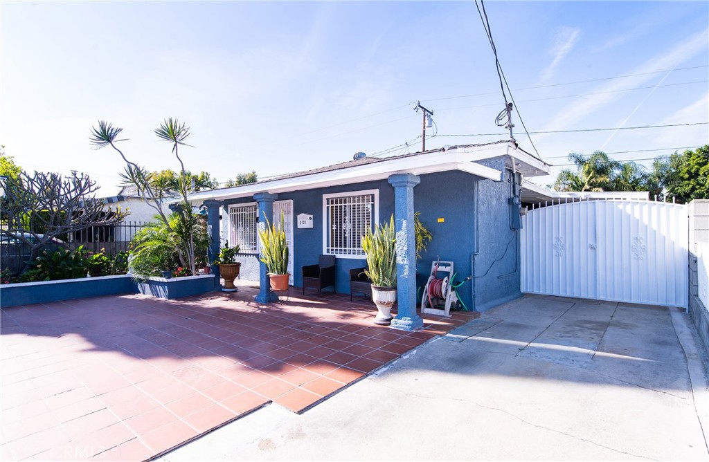 a view of a house with potted plants and a yard
