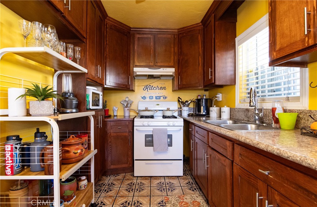 2121 East Shauer Street Compton, CA 90222 - Photo 16 of 30 a kitchen with stainless steel appliances granite countertop a stove a sink and dishwasher