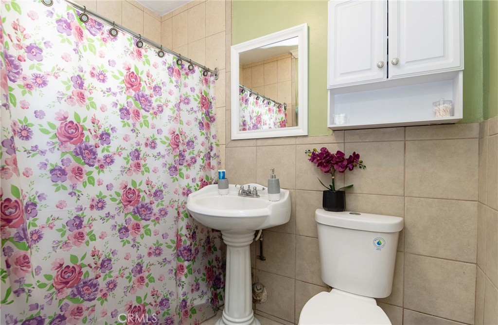2121 East Shauer Street Compton, CA 90222 - Photo 22 of 30 a bathroom with a sink and mirror with toilet