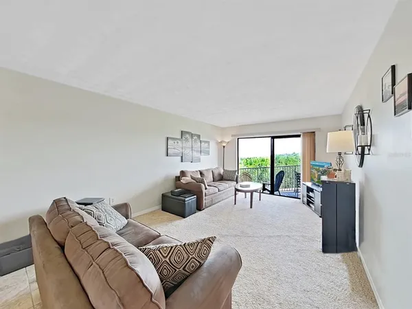 a living room with furniture large window and a table