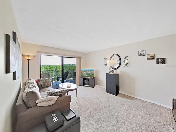 a living room with furniture a large window and a fireplace