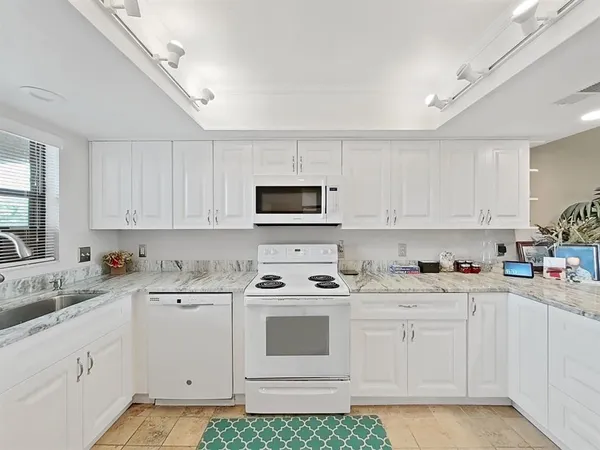 a kitchen with white cabinets appliances and sink