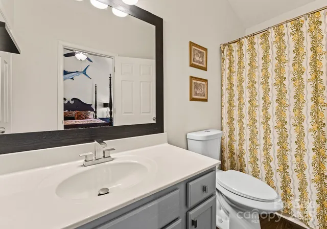 a bathroom with a sink a toilet and a mirror