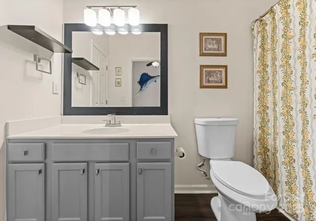 a bathroom with a toilet a sink and mirror