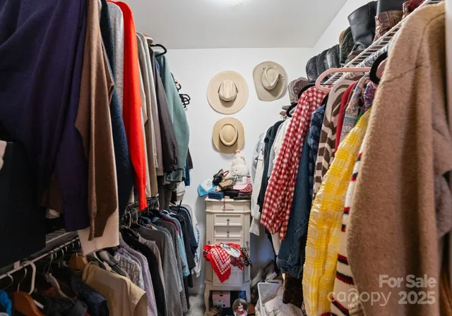 a view of walk in closet with clothes