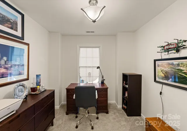 a view of a workspace with furniture and a window