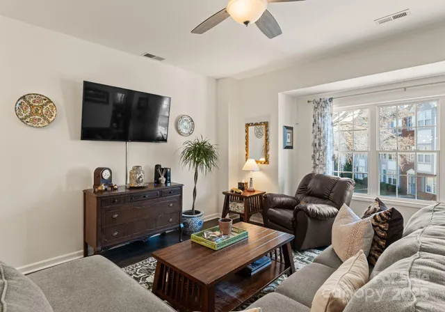 a living room with furniture a flat screen tv and a window