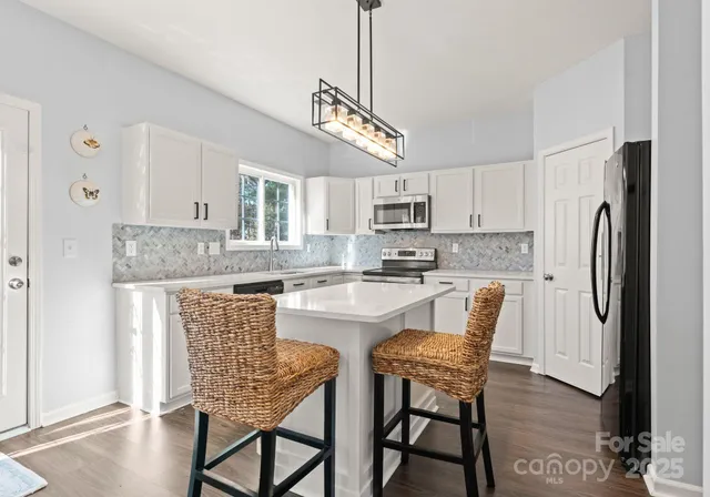 a kitchen with stainless steel appliances granite countertop a white cabinets and wooden floor