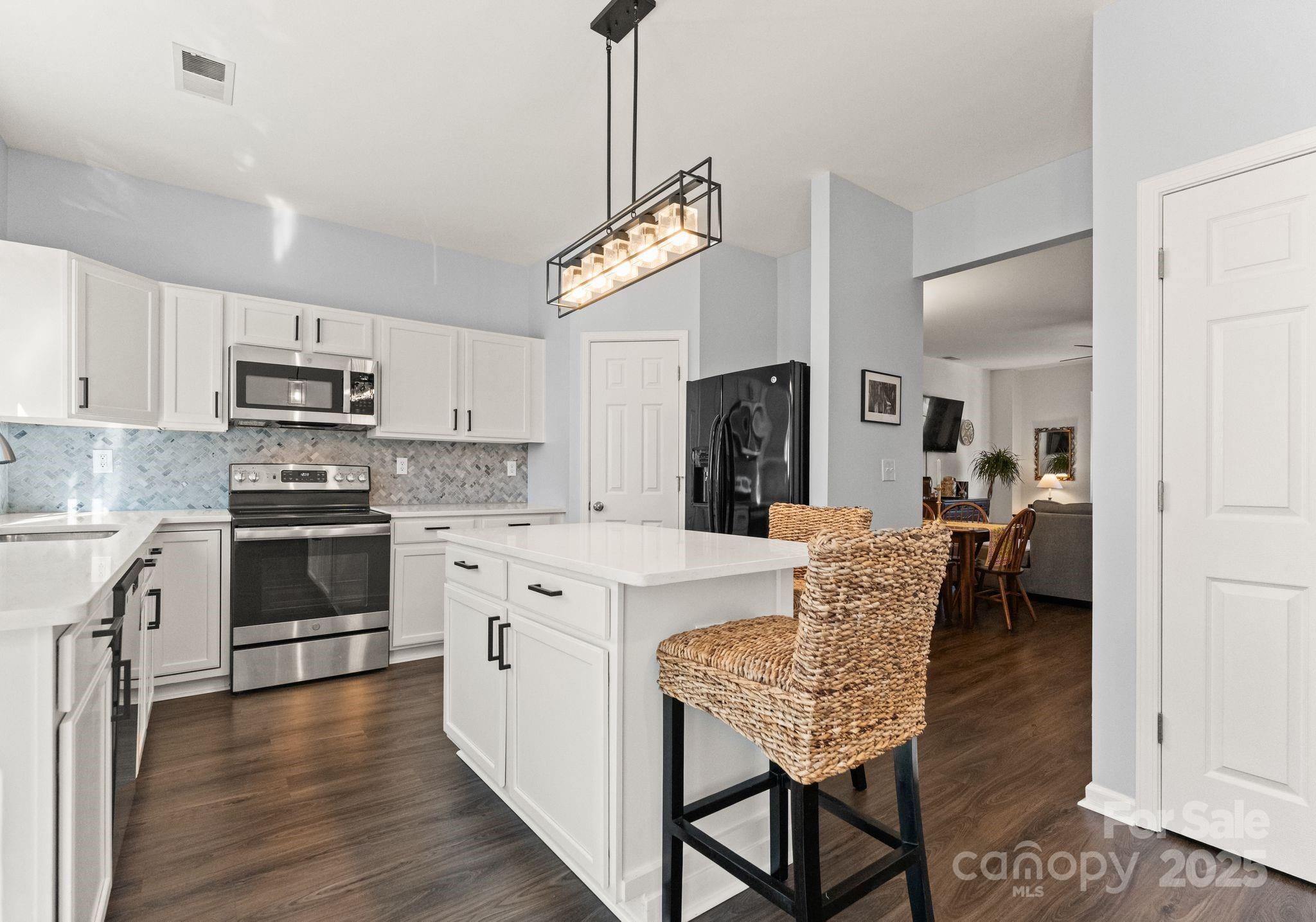 9930 Treeside Lane Matthews, NC 28105 - Photo 8 of 20 a kitchen with stainless steel appliances granite countertop a stove a sink dishwasher a refrigerator a oven with a dining table and chairs