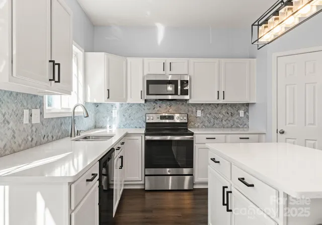 a kitchen with granite countertop a stove sink and cabinets