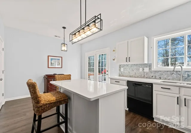 a open kitchen with stainless steel appliances granite countertop a sink and stove a refrigerator with white cabinets