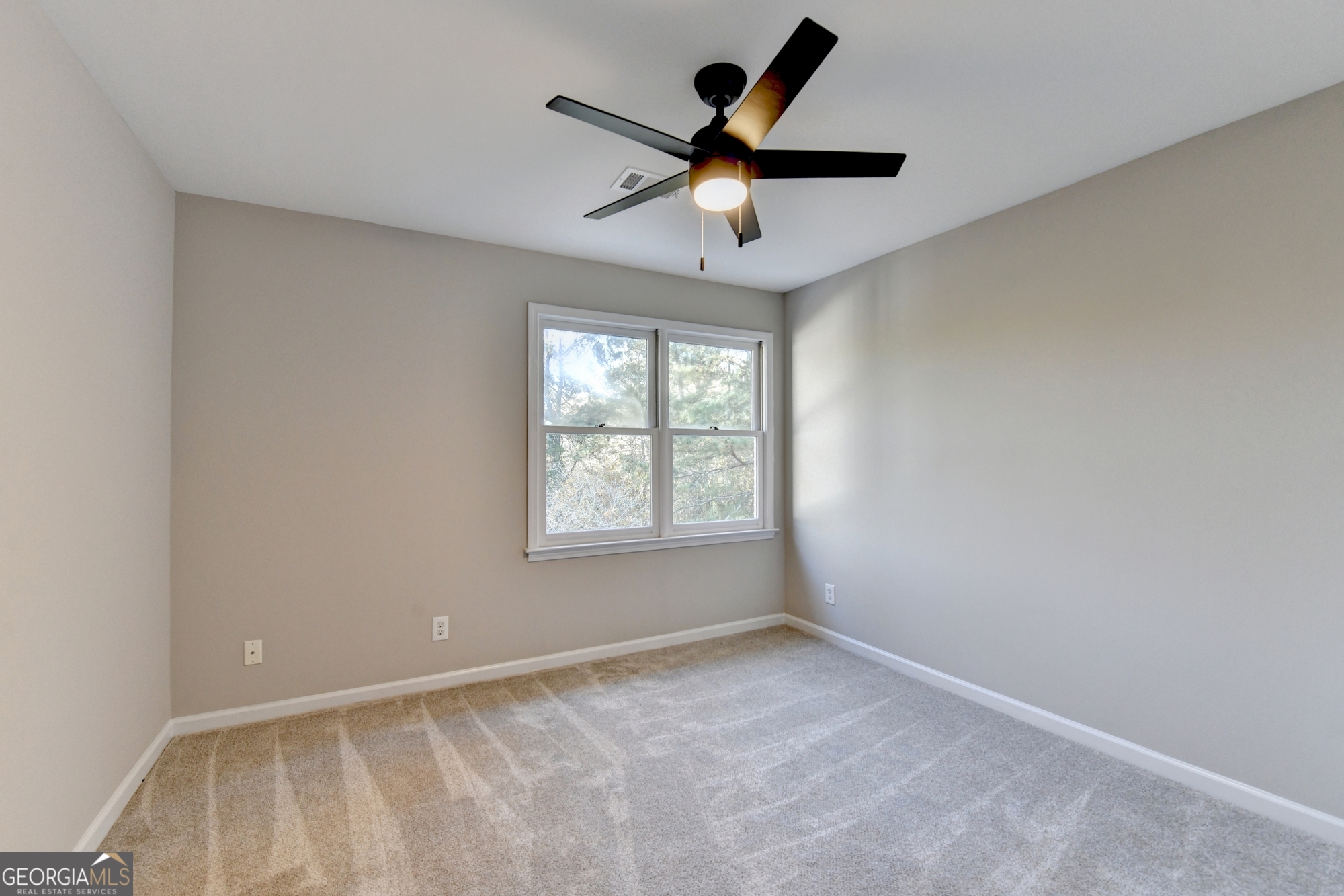 590 Manning Gin Road Monroe, GA 30656 - Photo 53 of 82 an empty room with a window and a fan