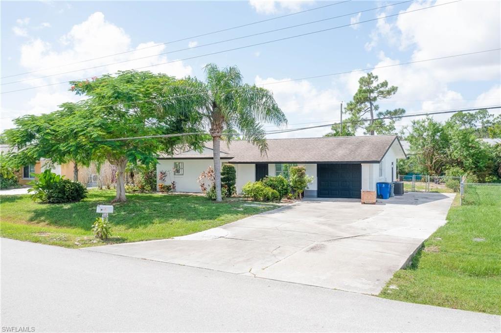 9104 Pineapple Road Fort Myers, FL 33967 - Photo 1 of 24 a front view of a house with a yard and a garage
