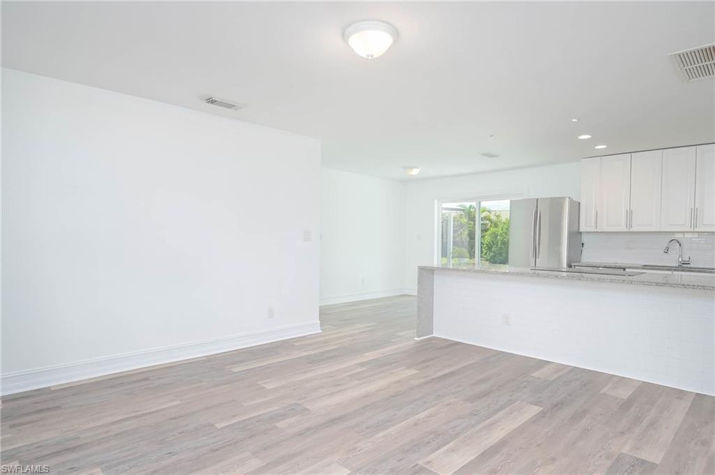 9104 Pineapple Road Fort Myers, FL 33967 - Photo 4 of 24 an empty room with wooden floor and window