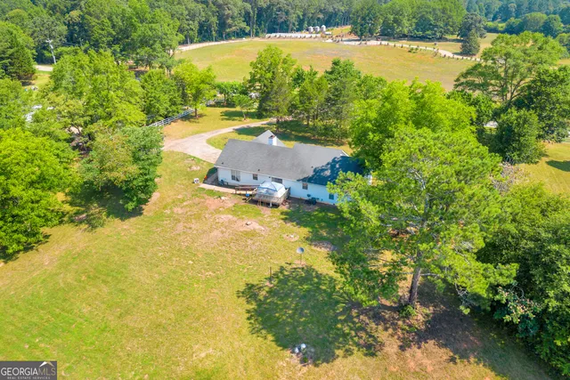 an aerial view of a houses with a yard and lake view