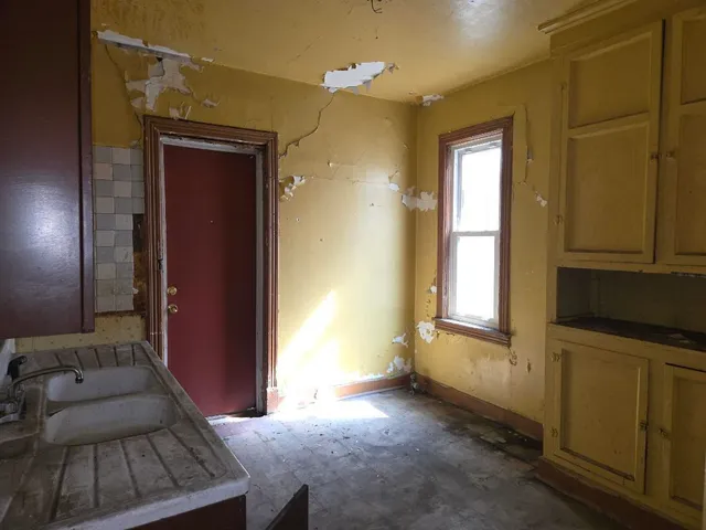 a view of a hallway with furniture and a window
