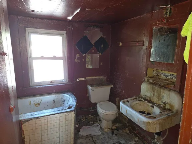 a white toilet sitting next to a bathroom sink and tub