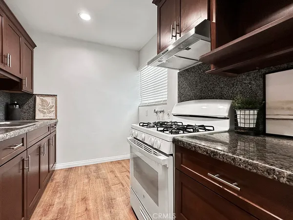 a kitchen with granite countertop stainless steel appliances and wooden cabinets