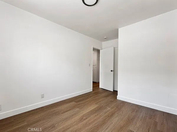 a view of an empty room with wooden floor and windows