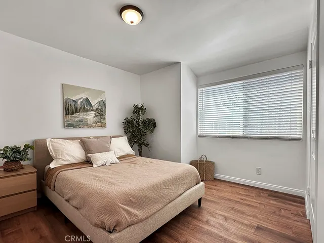 a bedroom with a bed and wooden floor