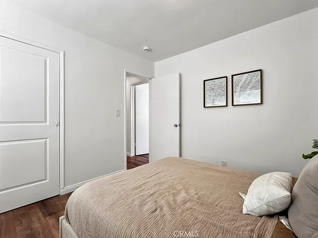 a bedroom with a bed a couch and potted plant