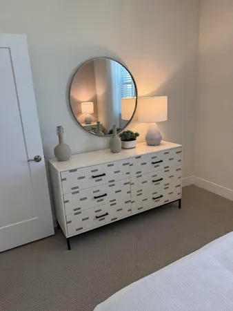 a view of a livingroom with furniture and mirror in it