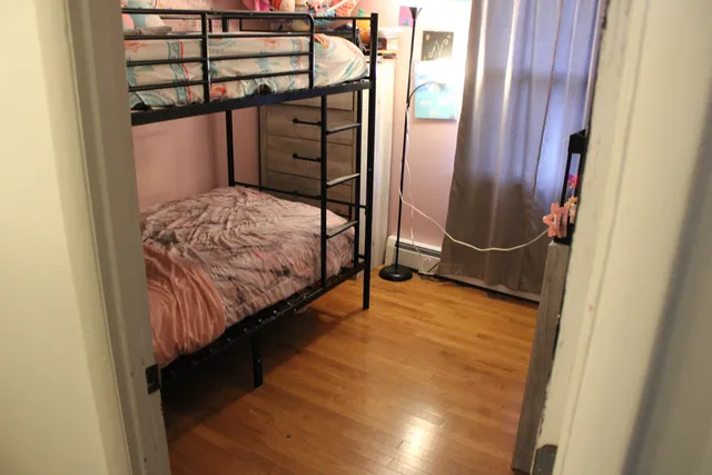 a bedroom with a bed and wooden floor