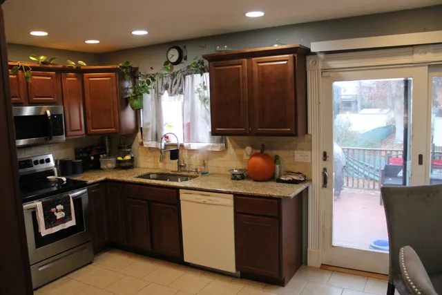 a kitchen with stainless steel appliances granite countertop a stove a sink and a microwave